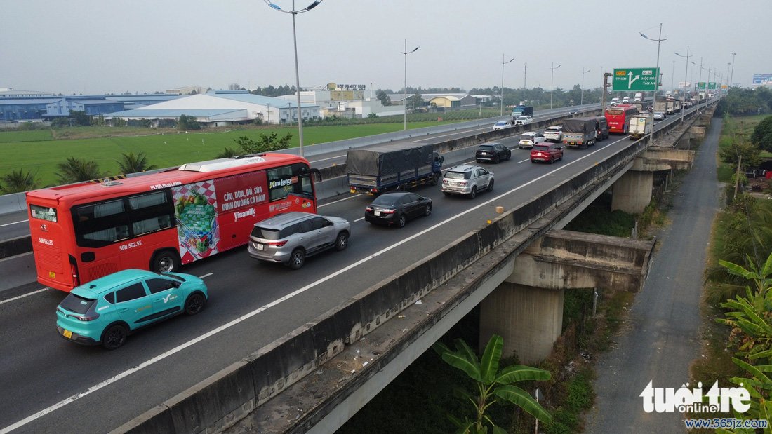 Xe đò tranh thủ quay đầu rước khách từ thành phố về quê khiến cao tốc ùn ứ   - Ảnh 1.